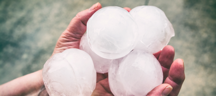 A hand holding large hail